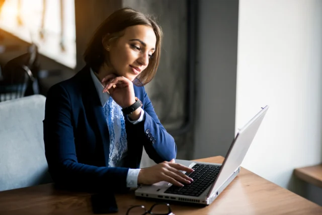 Mulher trabalhando em um laptop, com expressão pensativa, representando a atuação de headhunter Uberlândia.