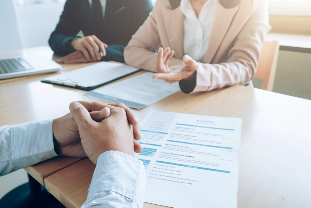 Recrutadores analisam currículo durante entrevista de emprego, representando a concentração de vagas no estado de São Paulo